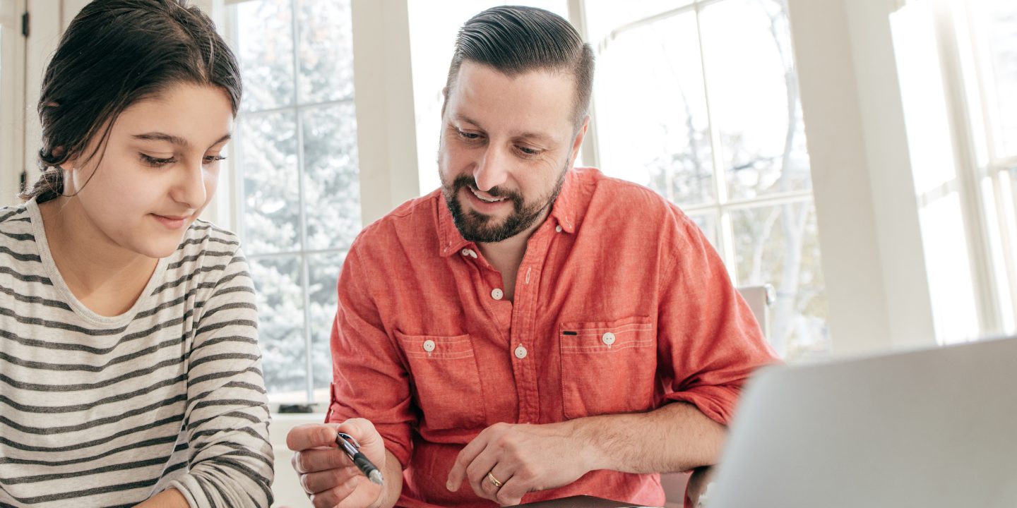 photo of a father guiding his daughter through an online bootcamp program for teens